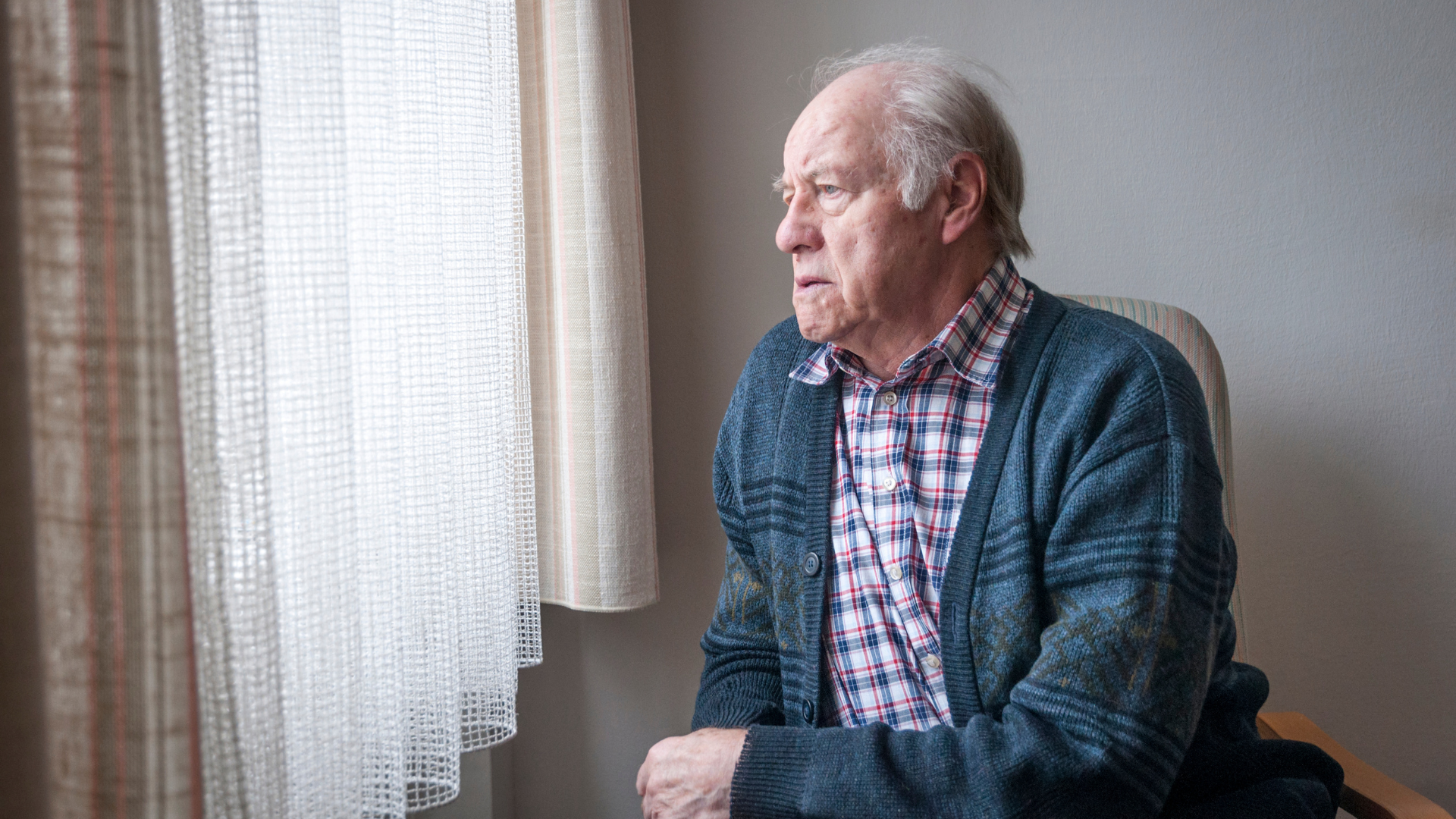 an older man looking out a window